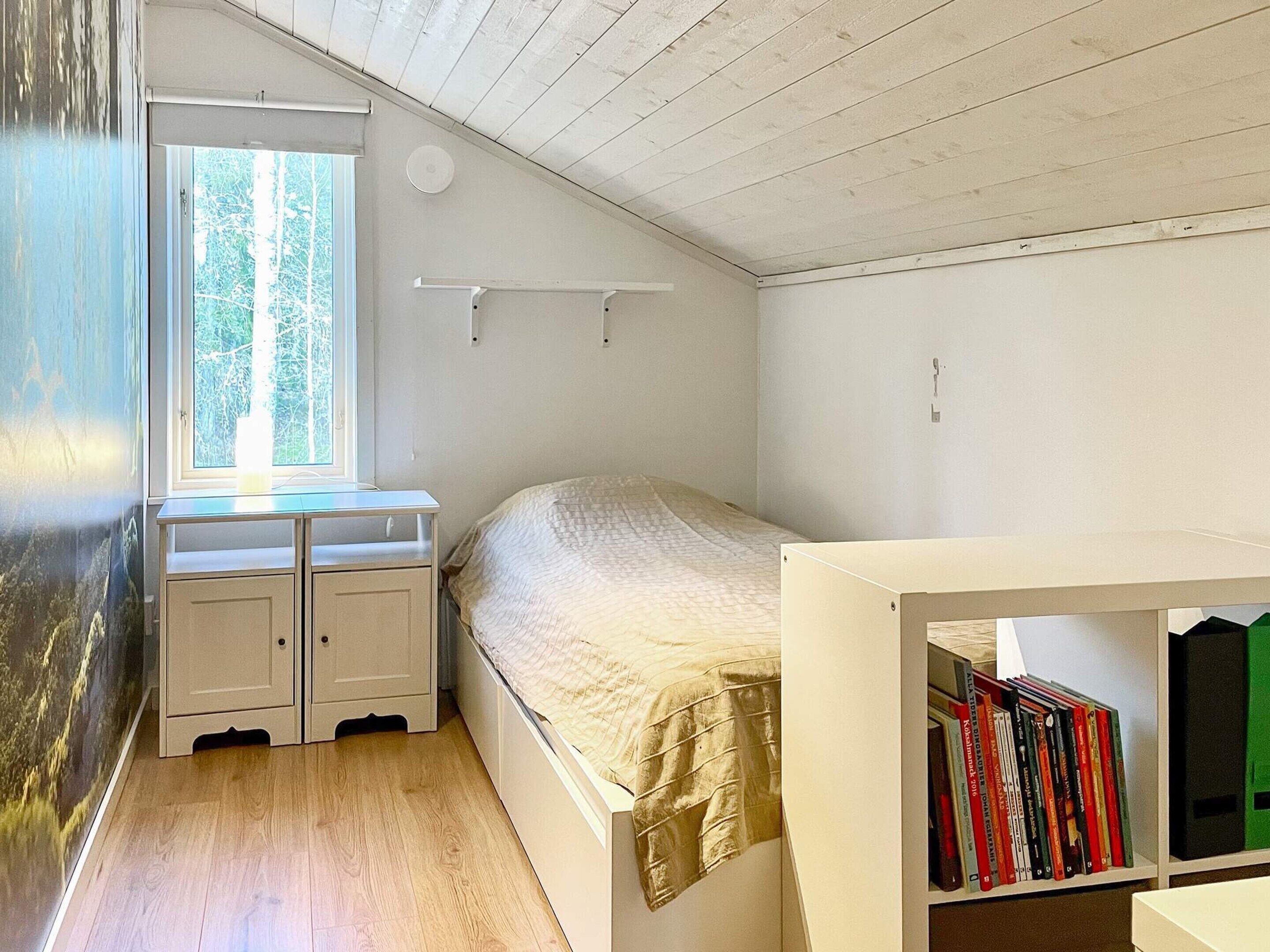 Ein Schlafzimmer mit einem Bett, einem Schreibtisch und einem Bücherregal.