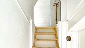 A wooden staircase with white walls and a white door at the top. - 4 Star Holiday Home in Morlunda (Mörlunda)