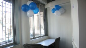 A room with a window, a table, and two striped chairs. - Fostel The Fort Hostel (Mumbai)