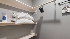 A bunk bed with white bedding, a shelf with a kettle and glasses, and a broom on the wall. - Hearthstone Hideaway at Tudor Suites (Eureka Springs)
