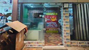 Der Eingang des Hotel Crystal Inn mit einem Schild, das den Namen und eine Willkommensbotschaft zeigt.