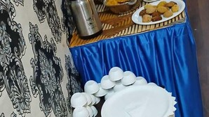 Ein Buffet mit verschiedenen Speisen, Geschirr und einer blauen Tischdecke.