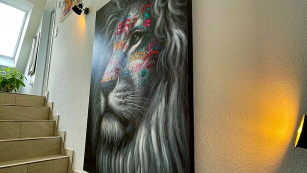 A staircase with a large, colorful painting on the wall.