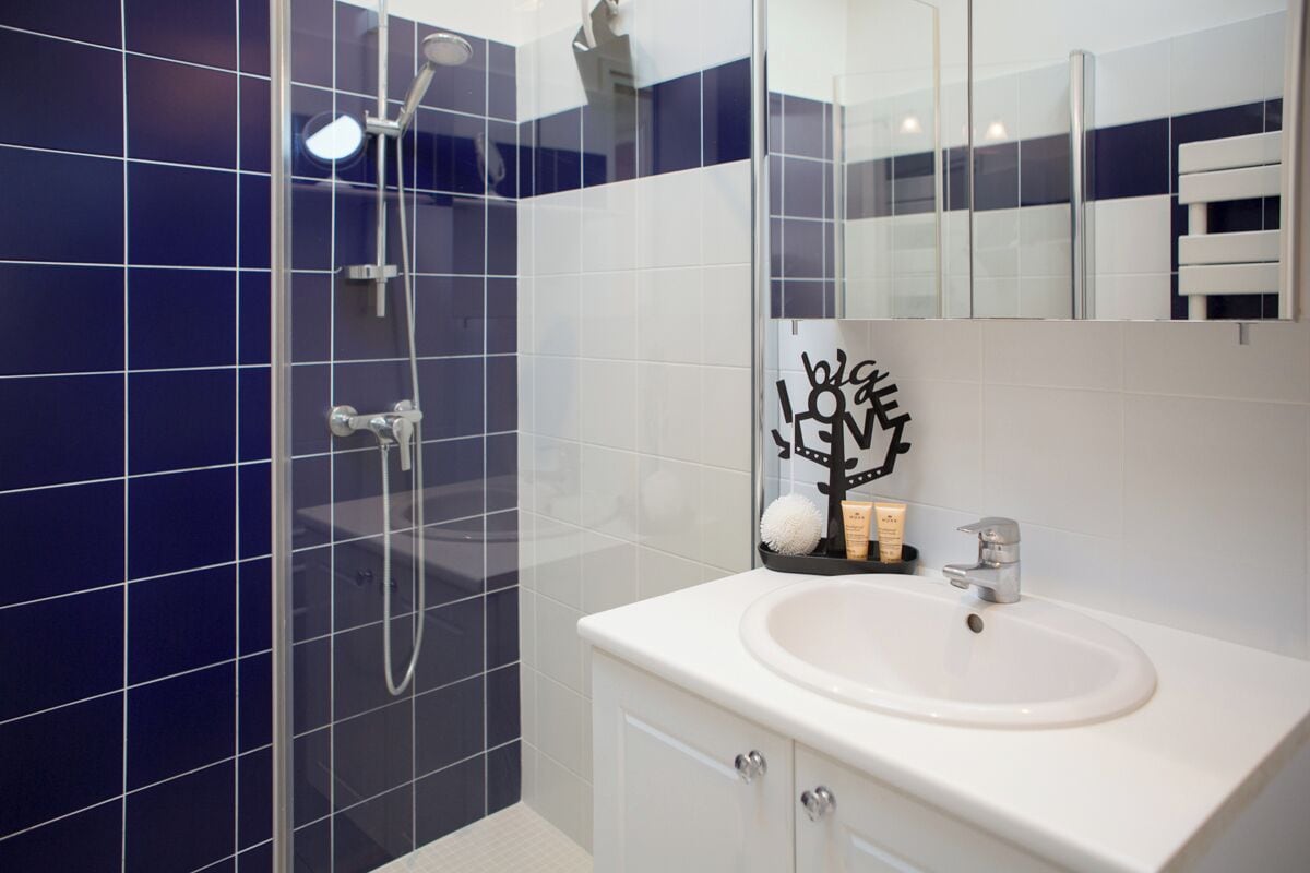 A bathroom with a shower, a sink, and a mirror.