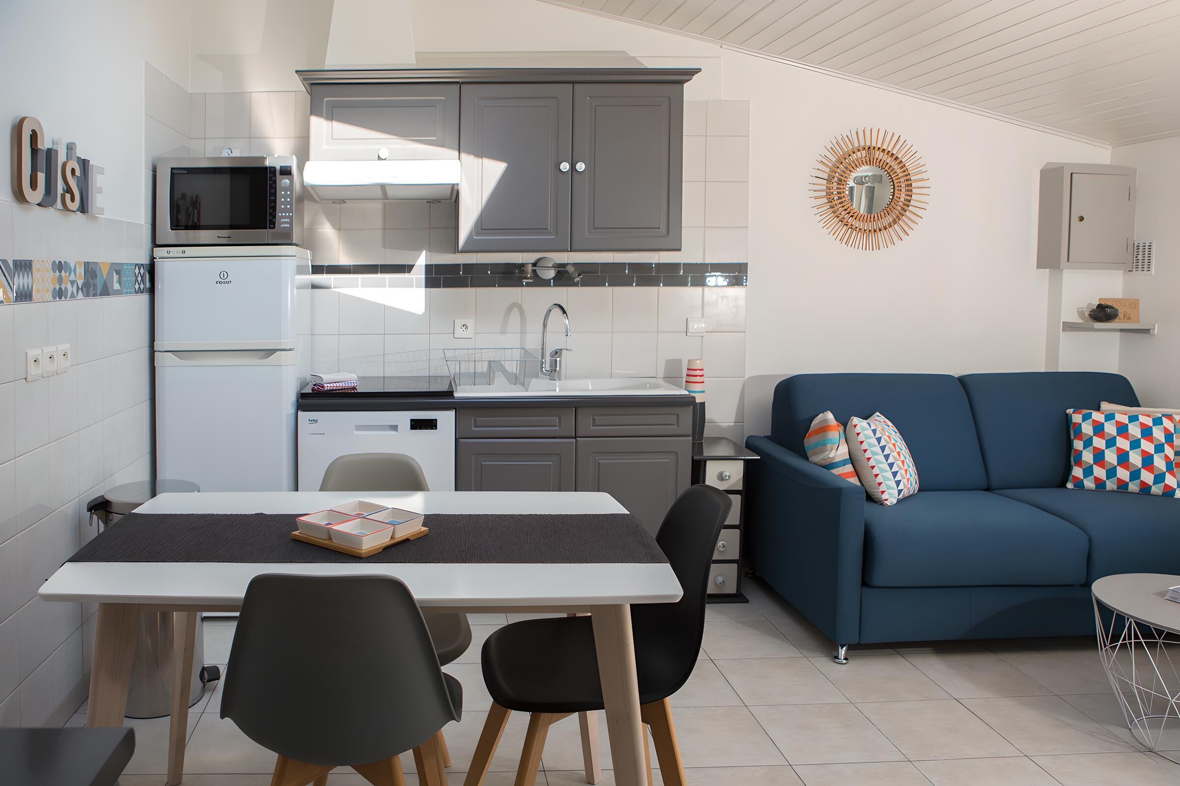 Un espacio habitable pequeño con kitchenette, comedor y sofá.