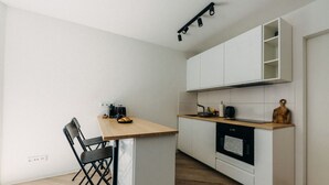 A compact kitchen with a wooden countertop, a black chair, and a coffee machine. - Design & comfort | Stylish & cozy | Netflix (Düsseldorf)