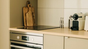 Une cuisine équipée d’une plaque de cuisson à induction moderne, d’appareils électroménagers en acier inoxydable et d’une planche à découper en bois.