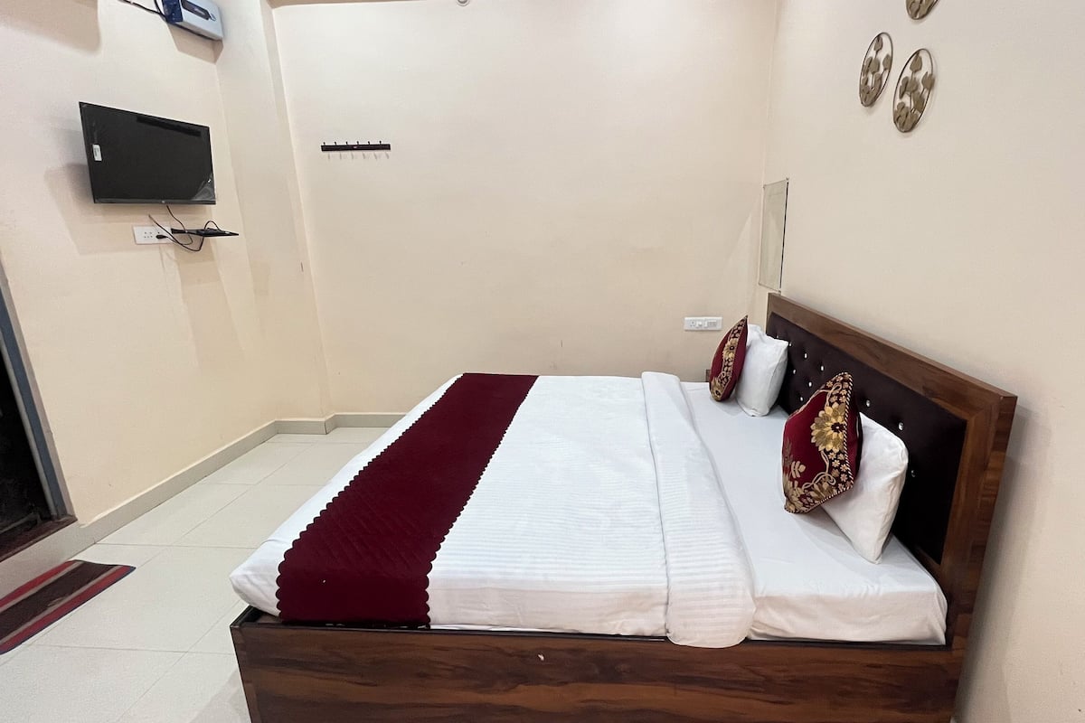 A neatly made bed with a wooden headboard, white bedding, and decorative pillows.