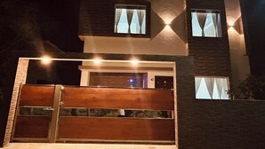 Ein modernes, zweistöckiges Haus mit einem befahrbaren Eingang und mehreren Fenstern.
