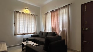 Ein Wohnzimmer mit einer Couch, einem Couchtisch und Vorhängen.