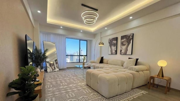 Une chambre moderne avec un grand lit, une télévision et une vue sur la ville.