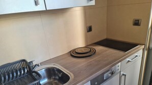 A modern kitchen with a stainless steel sink, a Bosch dishwasher, and a wooden countertop. - Studio Beni (Ljubljana)