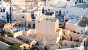 Un pueblo costero con edificios blancos, una plaza central y una zona de piscina.