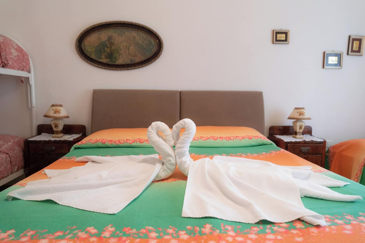 A hotel room with a bed, two nightstands, and a wall-mounted picture.