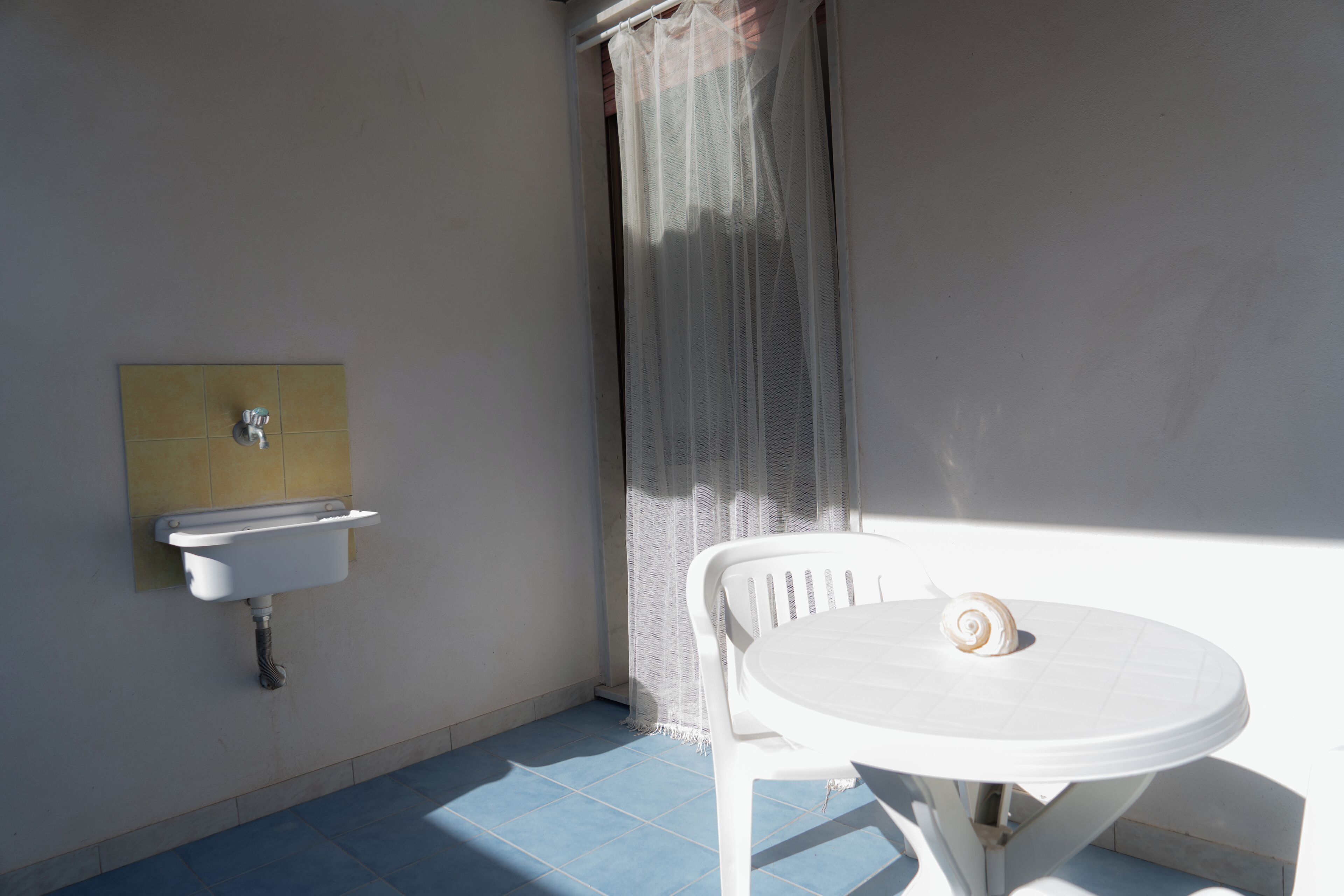 Un baño con un lavabo, una silla y una mesa.