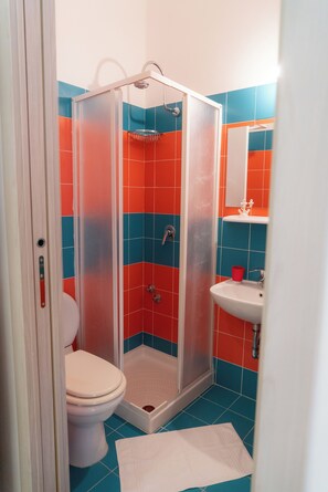 Baño con ducha, inodoro y lavamanos.