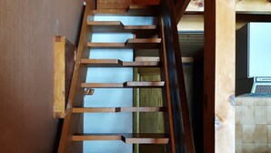 A wooden staircase with a handrail and a view of a kitchen area with a stove and tiles. - Mezzanine Studio 4 Pers, Parking, Near Châtel Center (Châtel)