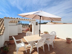 A patio with a table and chairs, an umbrella, and potted plants. - Apartment in S'Agaró for 5 persons with terrace (S'Agaró)