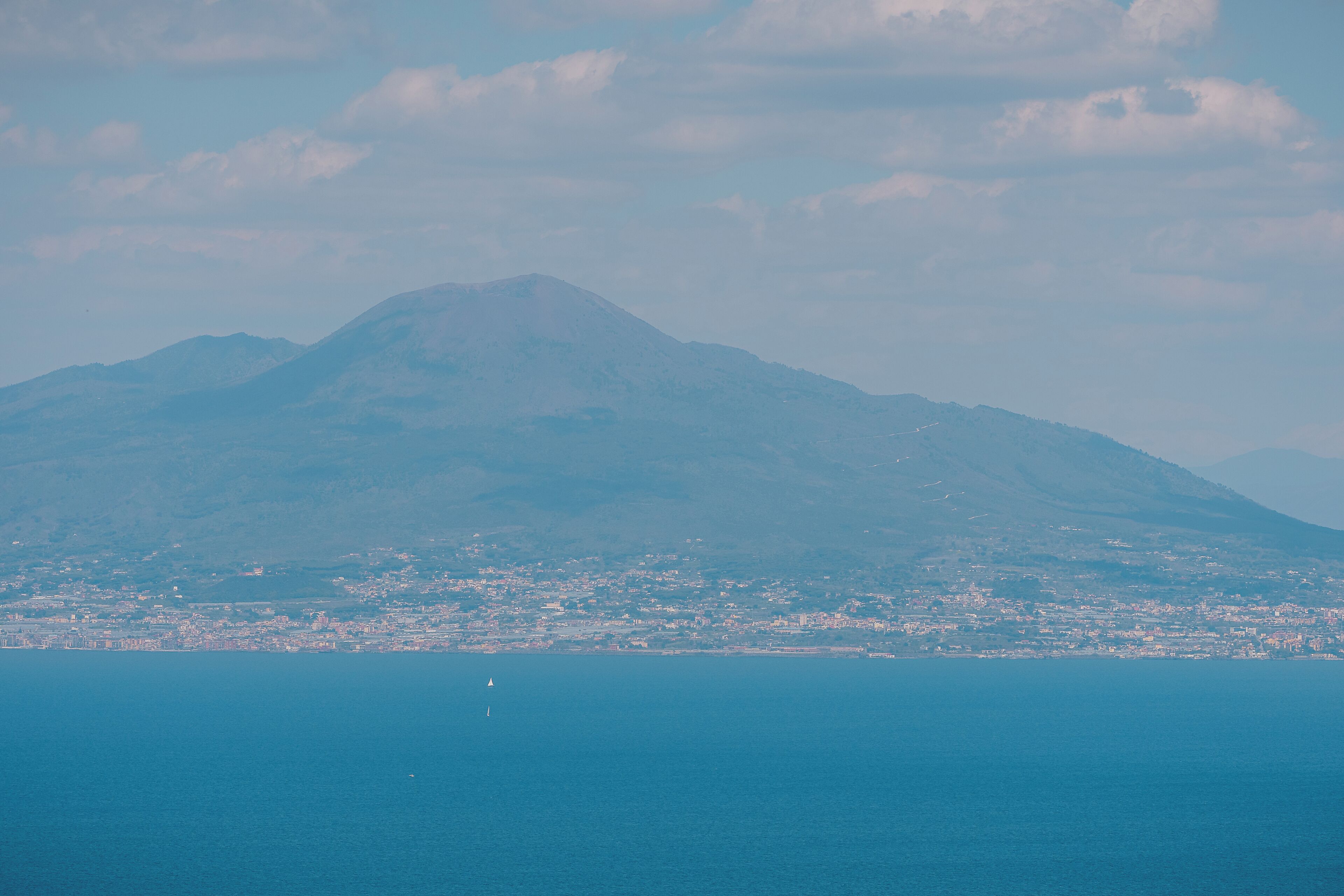 A coastal cityscape with a prominent mountain in the background.