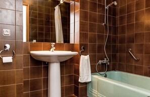 A bathroom with a sink, a bathtub, and a shower.