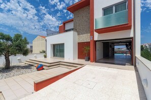 A modern two-story building with a stone facade, a balcony, and a pool area visible through the entrance. - House With Heated Pool all Year Round (Murtosa)