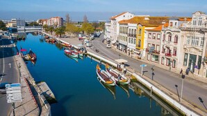 Un canal où sont amarrés des bateaux, une rue bordée d’immeubles et un ciel dégagé.