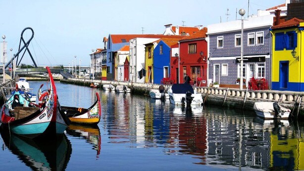 Un canal bordé d’immeubles aux couleurs vives et de bateaux.