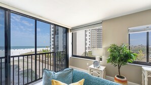 Een balkon met uitzicht op het strand en hoge gebouwen.
