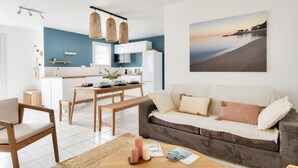 Un salon moderne avec un canapé, une table basse et un coin repas.