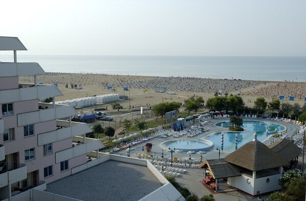 Un complexe hôtelier doté d’une grande piscine, d’une plage et de plusieurs bâtiments.