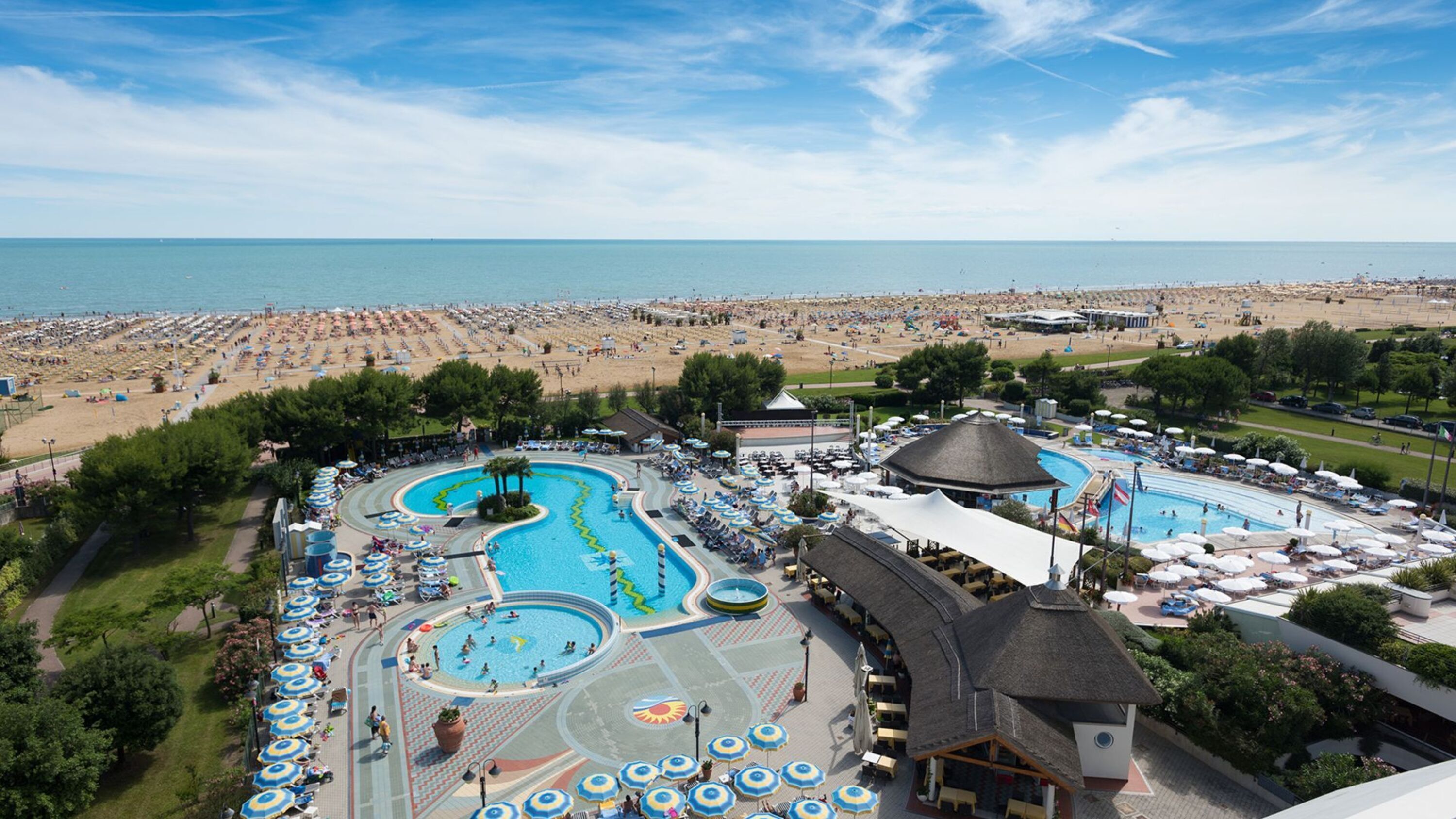 Un complexe hôtelier doté de plusieurs piscines, d’une plage et d’un grand nombre de chaises longues.
