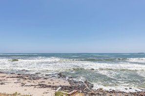 Ein Strand mit felsiger Küste und Wellen.