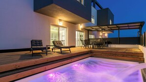 A modern outdoor pool area with a hot tub, wooden deck, and seating. - Villa Eva with pool near Medulin (Ližnjan)