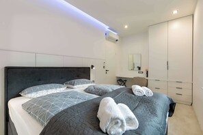A modern hotel room with a large bed, a desk, and a wardrobe. - Villa Franka with pool near Medulin (Ližnjan)
