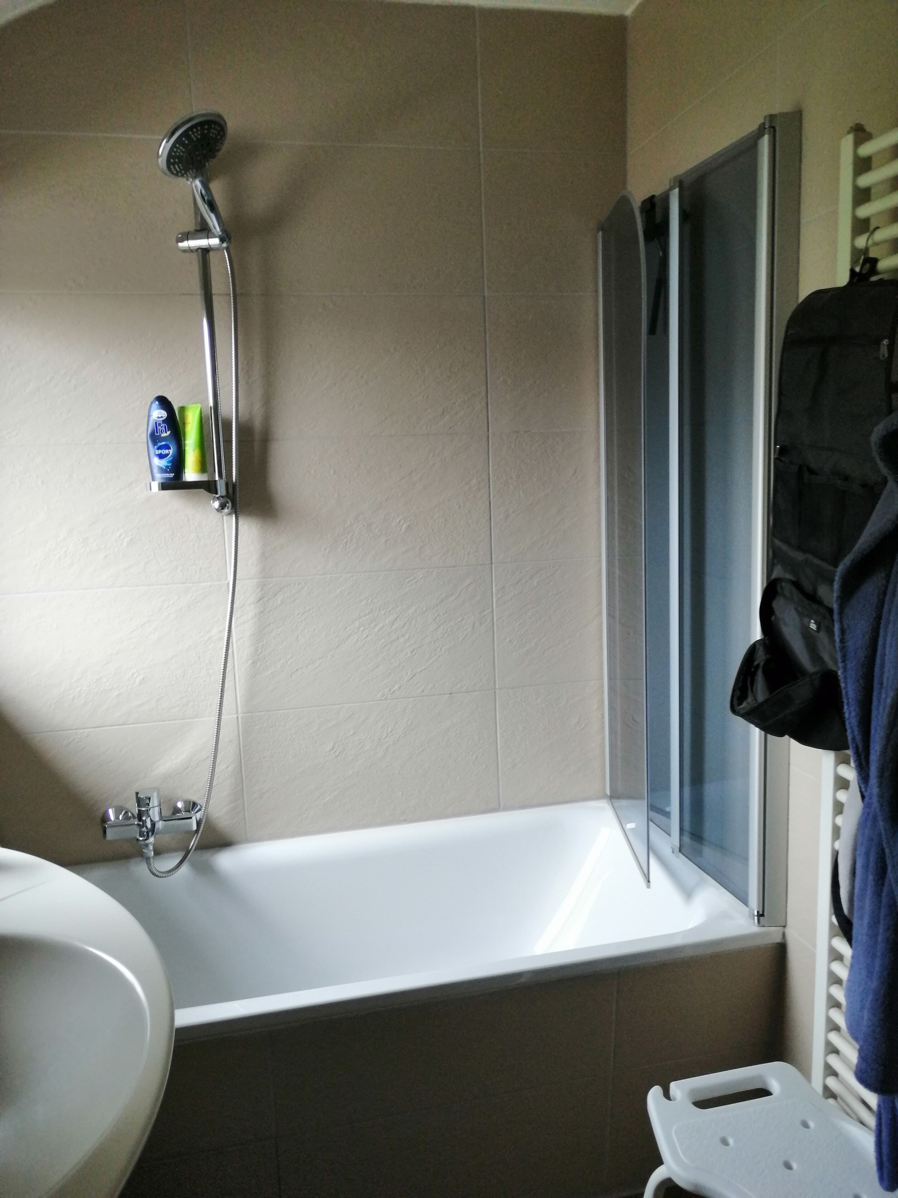 A bathroom with a bathtub, a shower, and a sink.