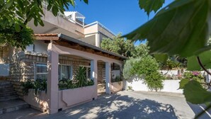 A modern house with a patio area, stone steps, and potted plants. - Appartamento Nomads Ac Wifi Hvar (Hvar)