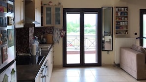 Ampla sala de estar com cozinha, varanda e sofá.