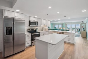 Una cocina moderna con electrodomésticos de acero inoxidable, una isla central y vistas al exterior.