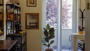 A kitchen with a dining area, a potted plant, and a door leading outside. - Vatican Dolce Remy Guest House (Rome)