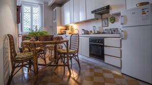 A kitchen with white cabinets, a dining table with chairs, a stove, and a refrigerator. - Apartment 3bedr 2bathr,FreeParking,CITY CENTER, Cosy and Chic, SEA VIEW (Palermo)