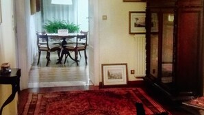A dining area with a table and chairs, a red carpet, and a wooden cabinet with decorative items. - Apartment 3bedr 2bathr,FreeParking,CITY CENTER, Cosy and Chic, SEA VIEW (Palermo)