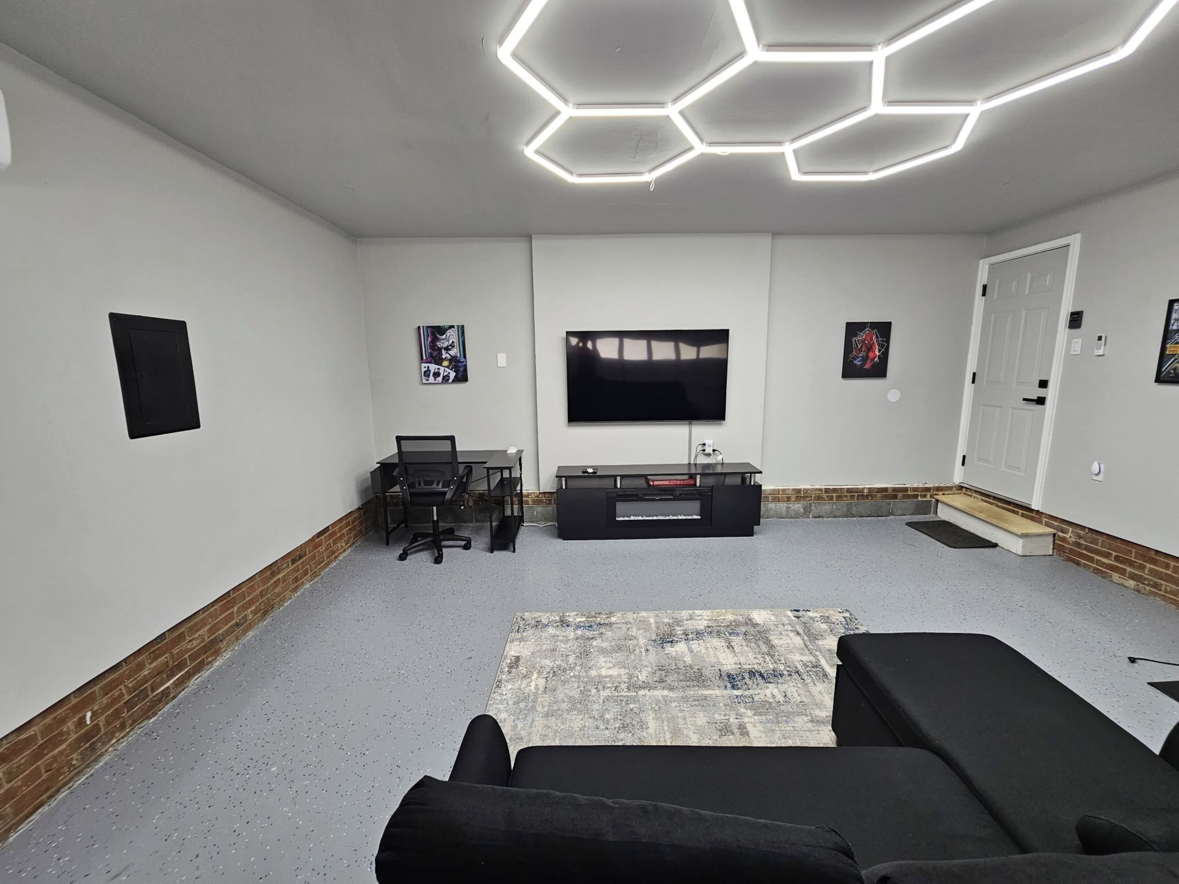 Una sala de cine en casa moderna con un televisor de pantalla plana grande, un mueble multimedia negro y una zona de estar cómoda con dos sillones reclinables.
