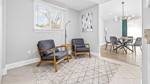 A modern living room with two leather chairs, a small round table, and a patterned rug. - Quail Ridge 3BR House (Charlotte)