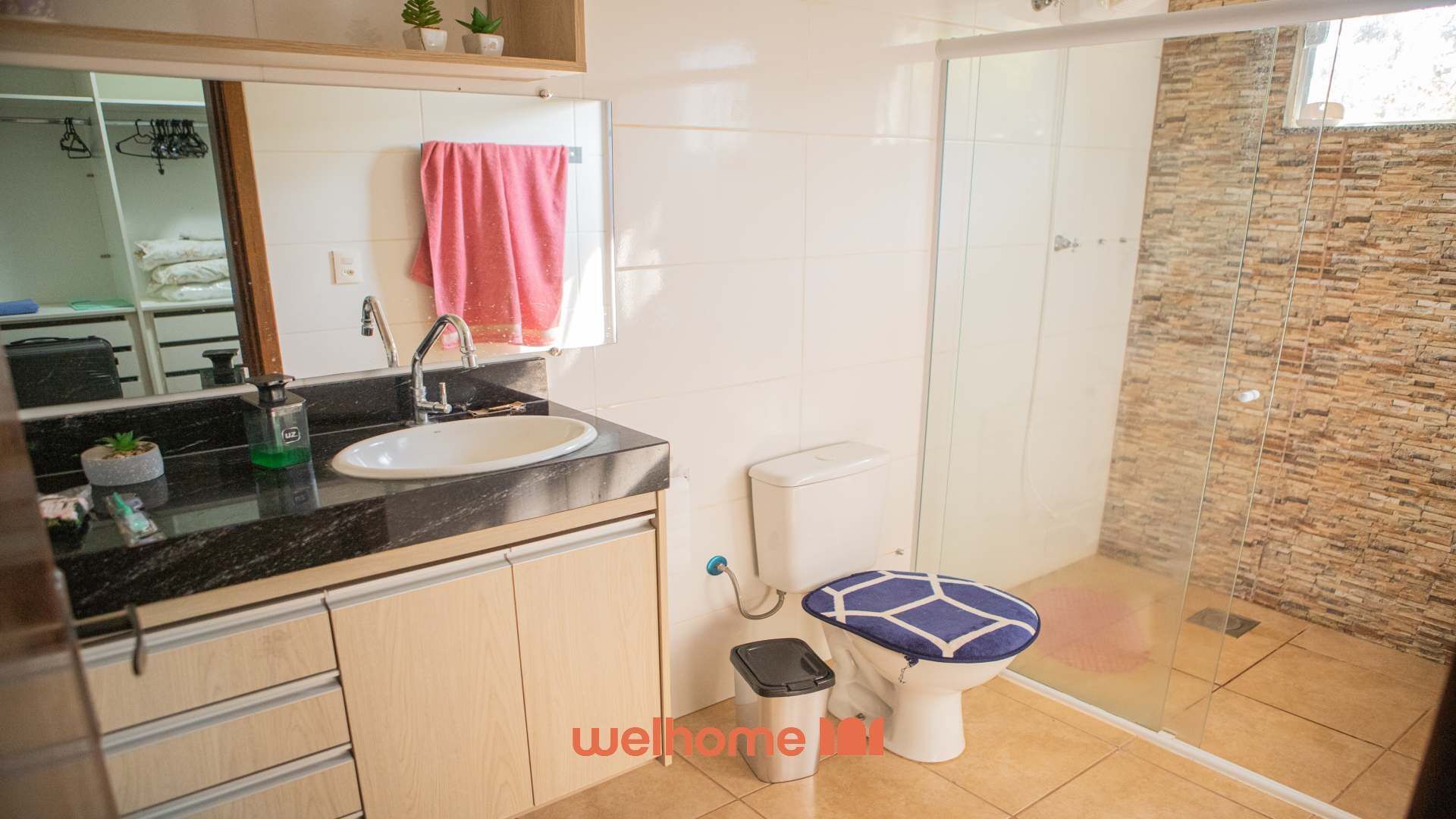 A modern bathroom with a sink, mirror, and toilet.