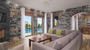 A living room with stone walls, a sofa, a coffee table, and a TV. - Turtulli Castle Stone Villa 2 - Private Pool Oasis (Hersonissos)