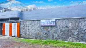 Un edifici amb mur de pedra i un rètol que diu "GUEST HOUSE GLORY".