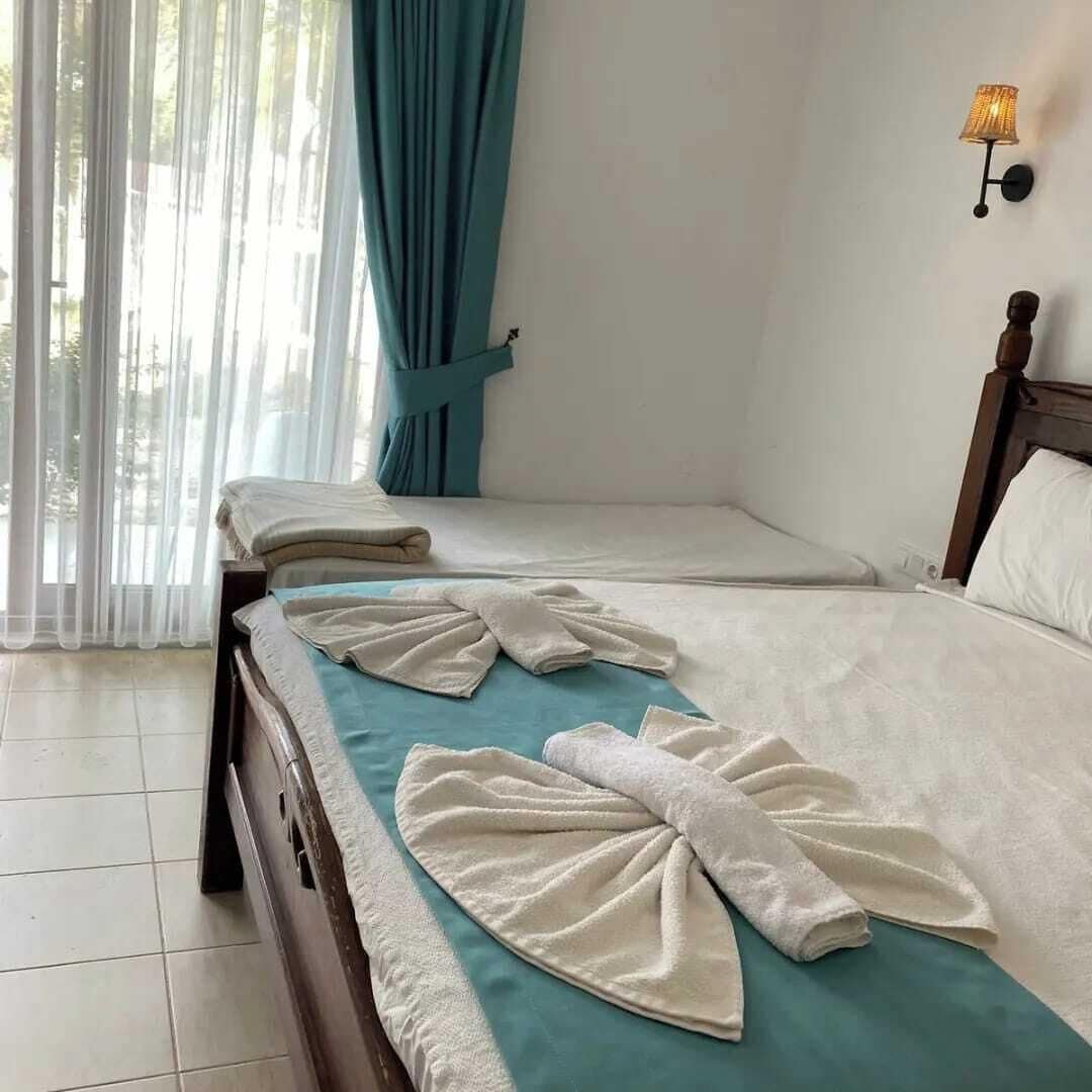 Habitación triple estándar, varias camas, vista al jardín, frente al mar | Ropa de cama 