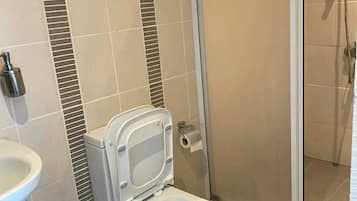 Standard Studio Suite, Partial Sea View, Beachfront | Bathroom | Shower, hair dryer, towels, soap