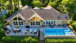 A two-story house with a large deck, a swimming pool, and a covered patio area. - 104 Baynard Cove - 11th Tee Box on The Harbour Town Golf Links with Pool. (Hilton Head Island)