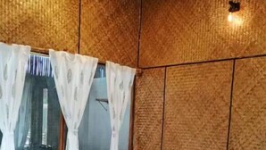 Een slaapkamer met een bed, gordijnen en een raam.